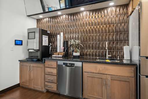 A kitchen with wooden cabinets and a stainless steel dishwasher.