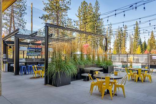 A patio with tables and chairs and a canopy.