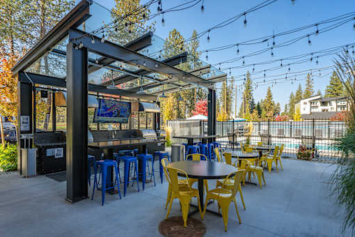 A patio with tables and chairs and a bar.