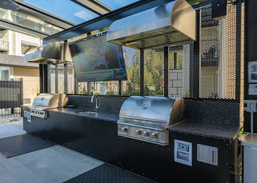 A black outdoor kitchen with a grill and sink.