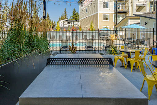 A pool area with a concrete platform and yellow chairs.