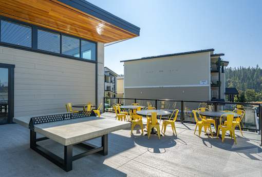 A patio with a table and chairs is in front of a building.