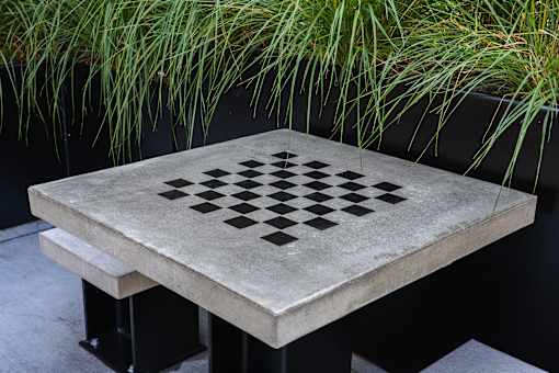 A concrete table with a checkerboard pattern in the middle.