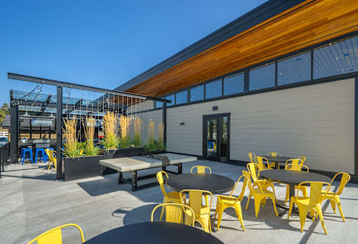 A patio with tables and chairs is set up outside a building.