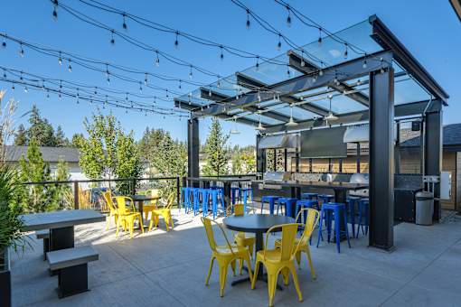 A patio with tables and chairs under a pergola.