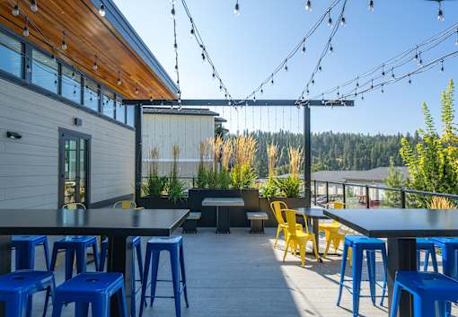A patio with blue stools and yellow chairs.