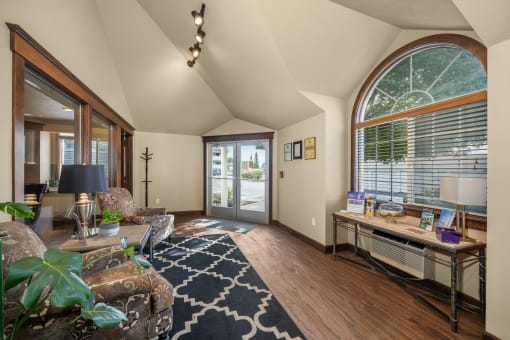 a living room with a large arched window and a couch and a desk