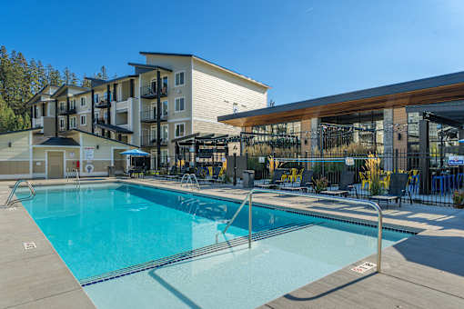 A large swimming pool in front of a building with a gym.