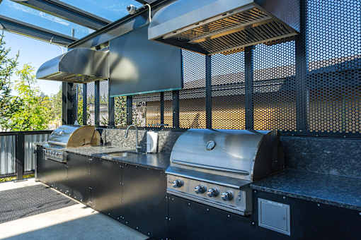 A modern outdoor kitchen with a grill and sink.