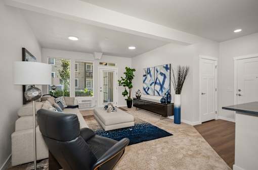 A living room with a black leather chair and a white couch.