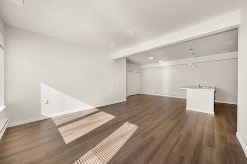 A room with wooden flooring and white walls.
