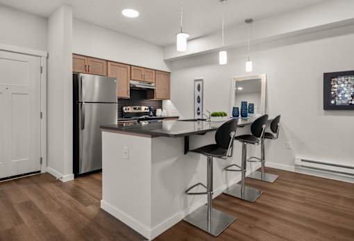 A kitchen with a white island and bar stools.
