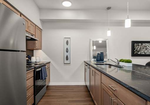A modern kitchen with a stainless steel refrigerator and wooden cabinets.