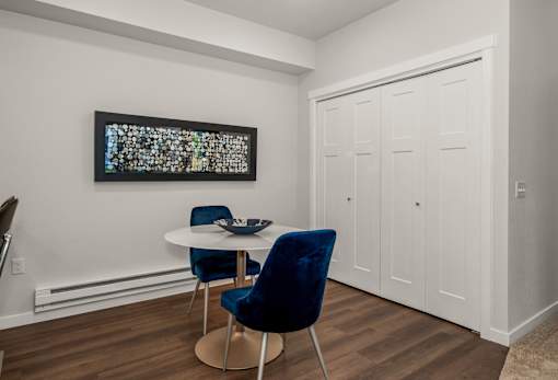 A blue chair sits in front of a white table with a bowl on it.