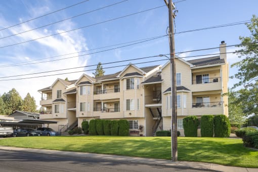 a row of apartment buildings on a green lawn