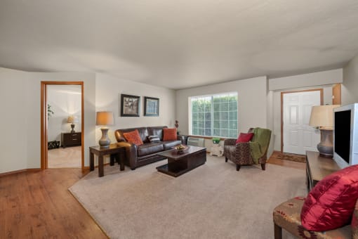 a living room with a couch and chairs and a tv