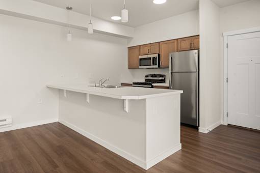 A kitchen with a white counter and wooden cabinets.