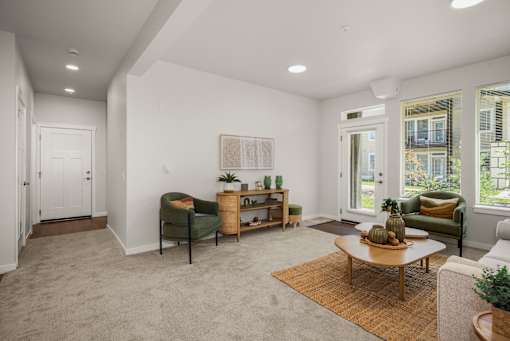 A living room with a green chair, a brown coffee table, and a painting on the wall.
