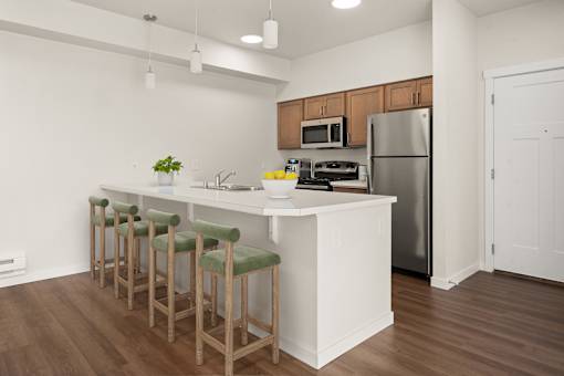 A kitchen with a white island and green bar stools.