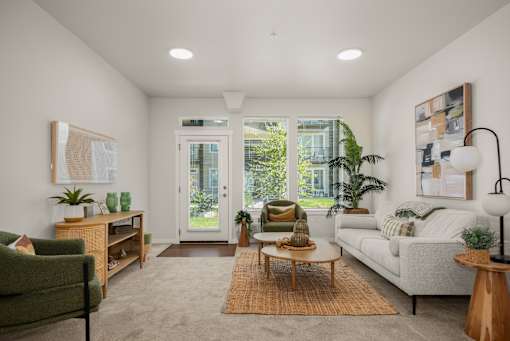A living room with a green chair, a white couch, and a wooden coffee table.