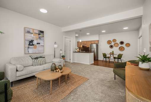 A living room with a grey couch, a coffee table, and a painting on the wall.