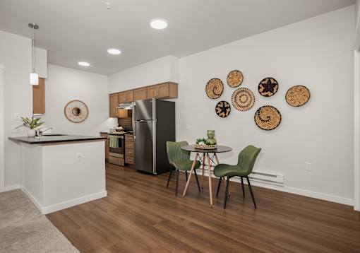 A kitchen with a table and chairs and a fridge.
