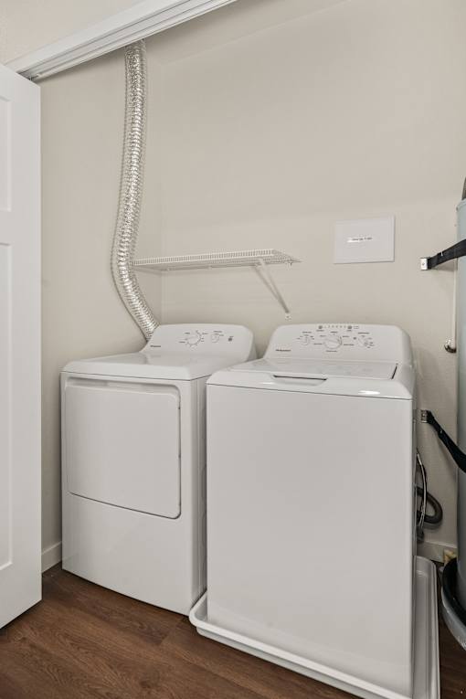 Two white front loading washing machines in a laundry room.