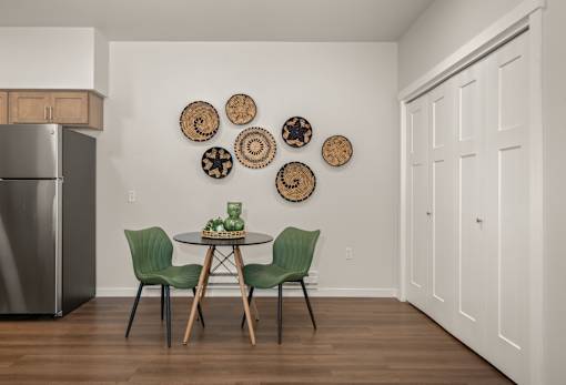 A kitchen with a table and chairs and a fridge.