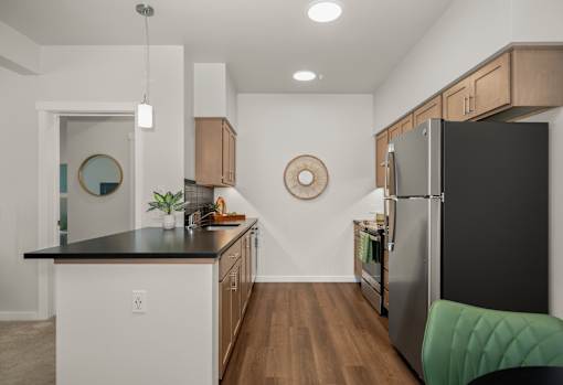 A modern kitchen with a black countertop and a black refrigerator.