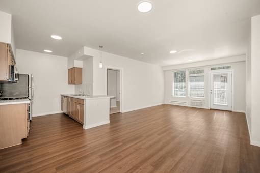 A kitchen with wooden floors and white walls.