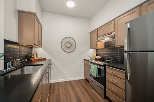 A kitchen with a black countertop and wooden cabinets.