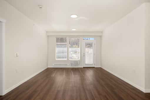 A room with a brown floor and white walls.