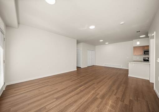 A room with wooden flooring and white walls.