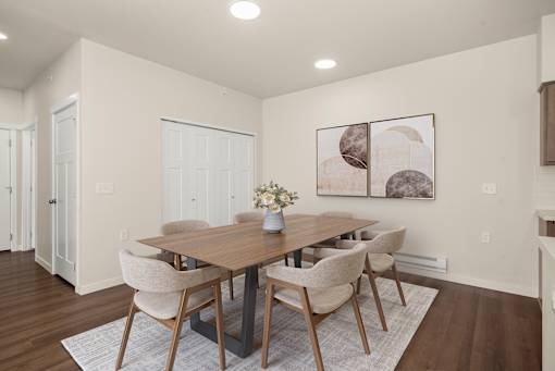 A dining room with a wooden table and chairs.