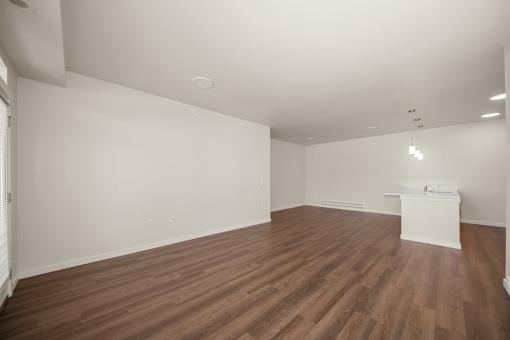 A room with wooden flooring and white walls.