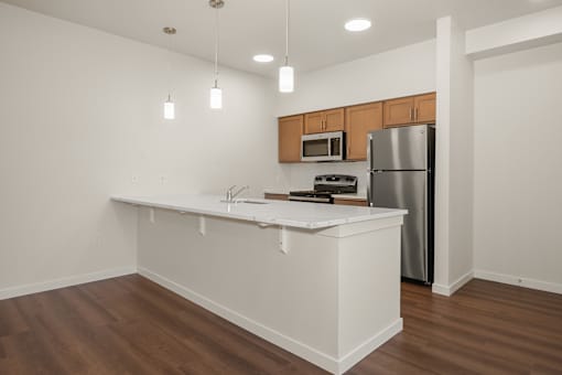 A kitchen with a white counter and wooden cabinets.