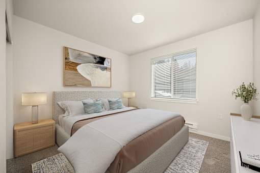 A bedroom with a large bed and a painting on the wall.