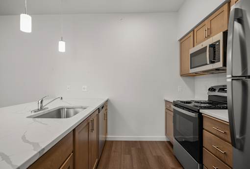A kitchen with a sink, stove, and refrigerator.