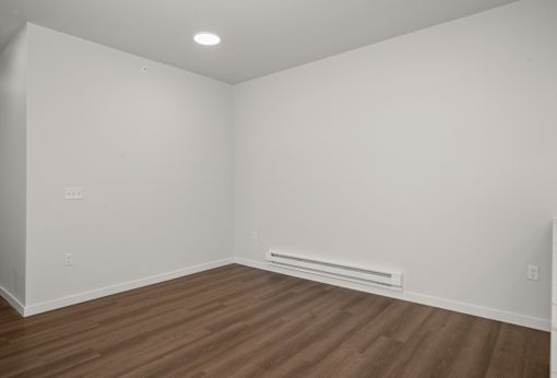A room with wooden flooring and white walls.