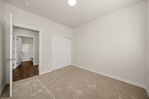 A room with a carpeted floor and a doorway leading to another room.