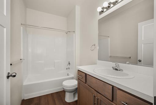 A white bathroom with a toilet, sink, and bathtub.