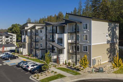 Apartment complex with a parking lot in front.