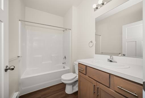 A white bathroom with a toilet, sink, and bathtub.