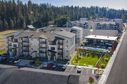 A large apartment complex with a parking lot in front.