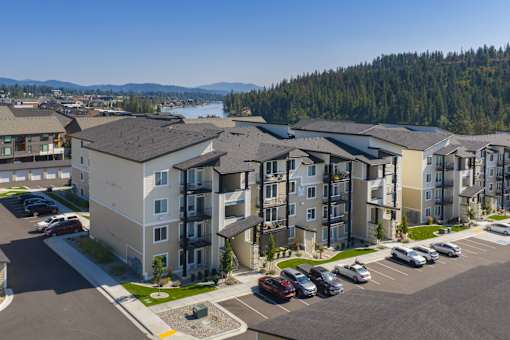 Apartment complex with a parking lot in front.