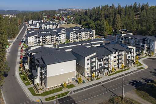 A large apartment complex with a parking lot in front.