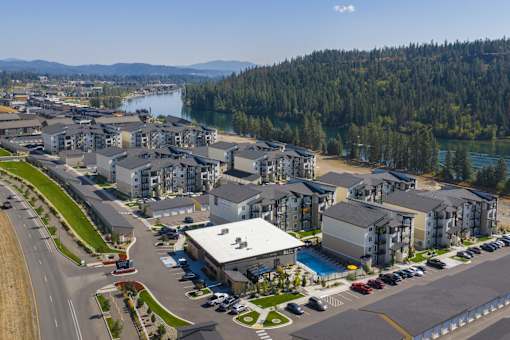 A large building complex with a parking lot in front of it.