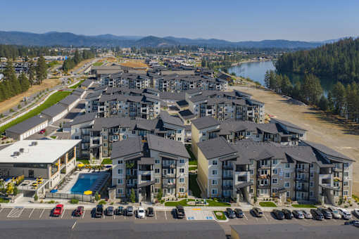A large residential complex with a swimming pool and a lake in the background.