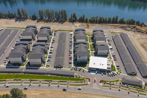 A large parking lot with several cars and a building in the background.