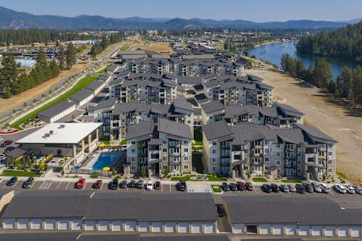 A large residential complex with a parking lot in front.